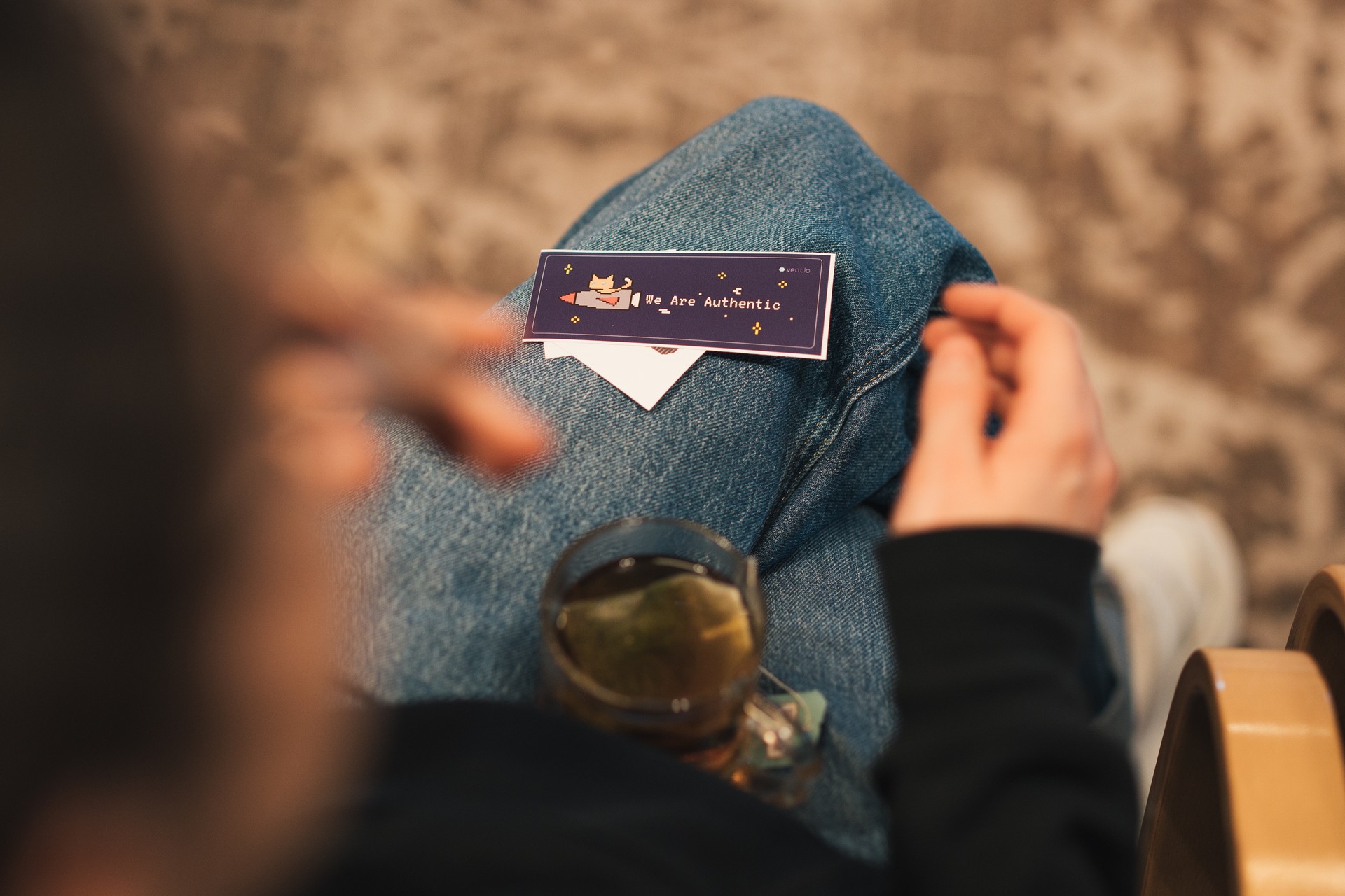 Ein vent.io Sticker liegt auf einem Bein